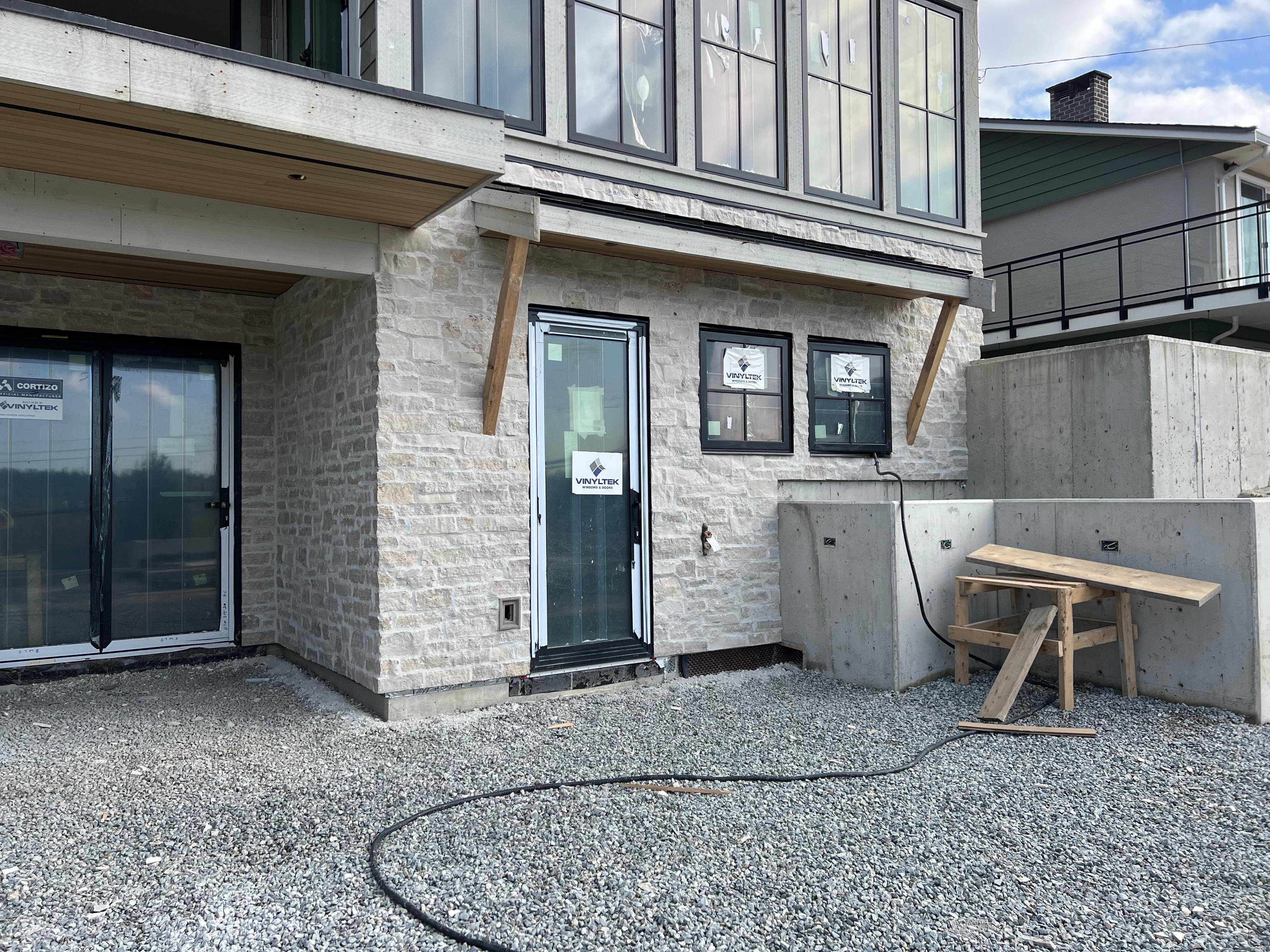 Light limestone veneer installed on a new home exterior